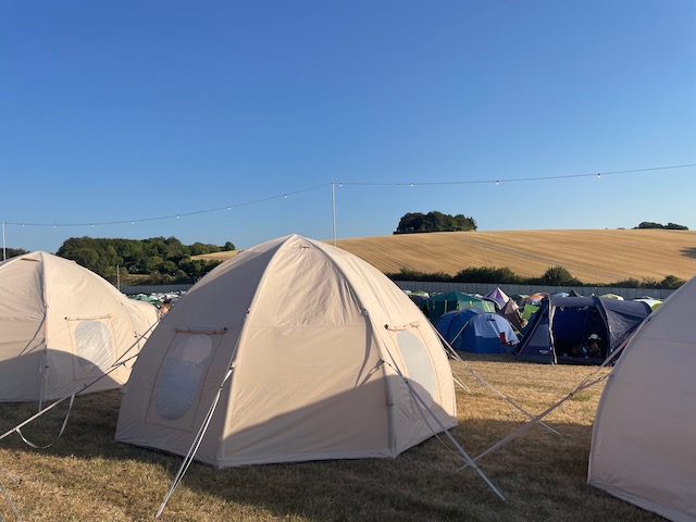 A row of CampAble tents on a sunny festival day