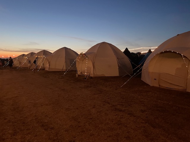 CampAble tents lit up with fairy lights at dusk